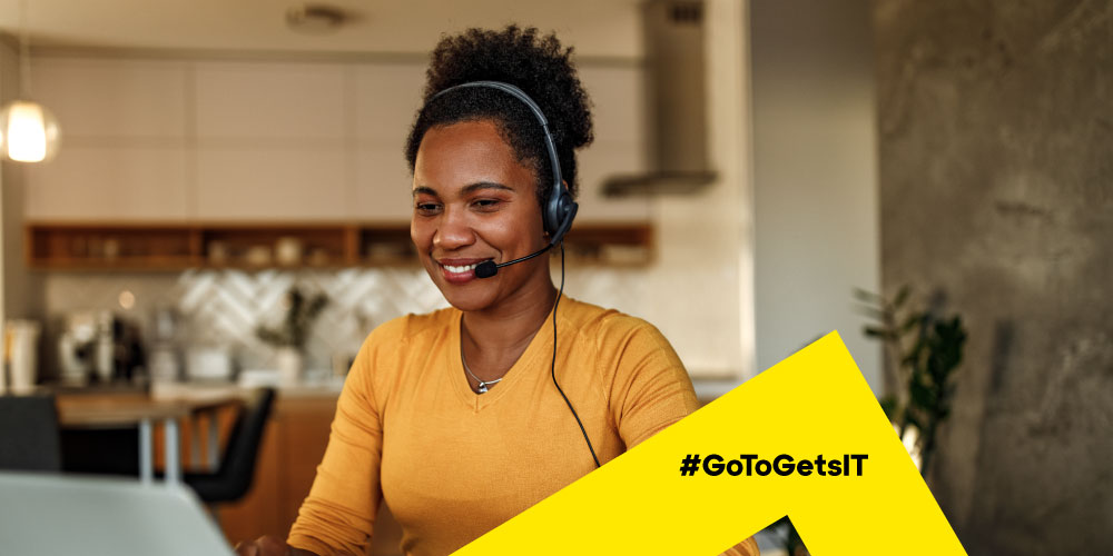 Une femme qui porte un casque-micro et qui travaille sur un ordinateur portable chez elle et active l'automatisation de PowerShell avec l'architecture de sécurité Zero Trust.