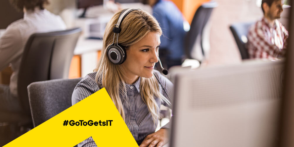 Agent informatique portant un casque audio travaillant dans un service desk à l’aide d’un logiciel d’alerte et de surveillance de serveur