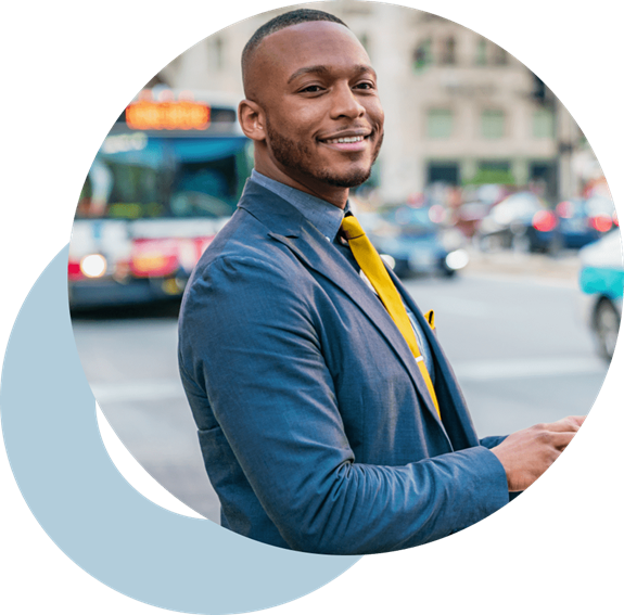 Business man in an urban setting smiling.