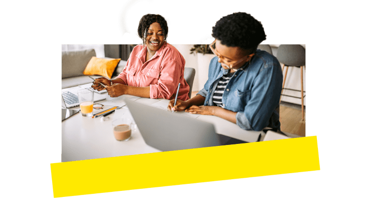 Deux collègues rigolent et passent un bon moment alors qu’ils travaillent à distance.