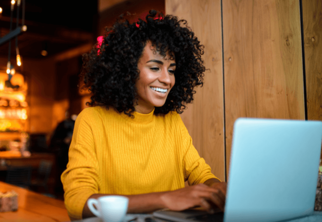 Smiling woman working on a laptop.