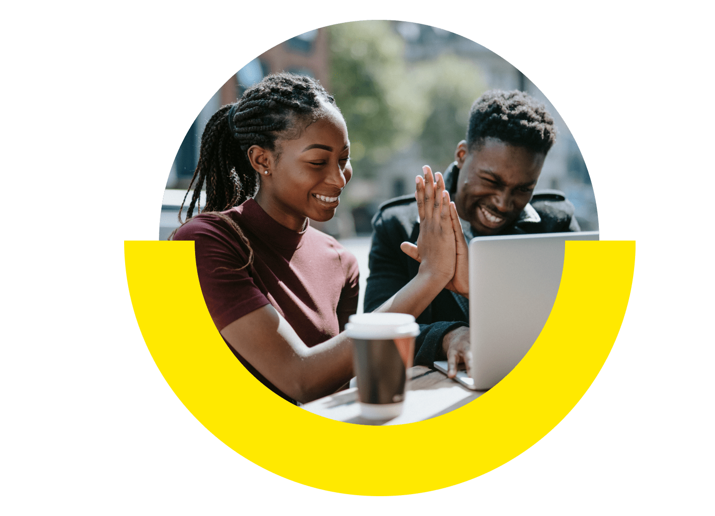 Two people high fiving in front of their laptop