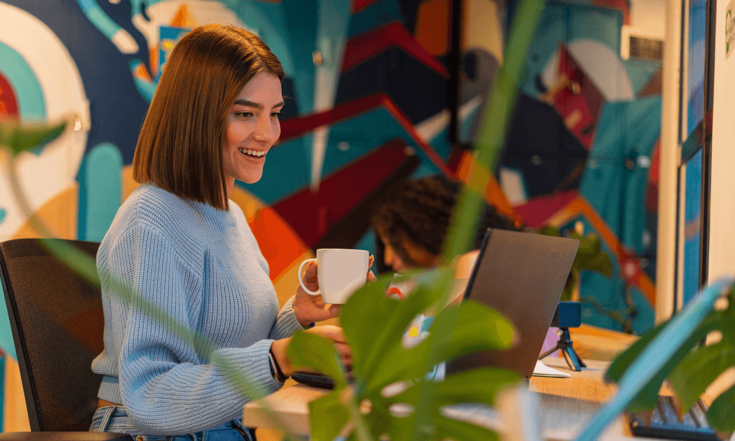 Smiling woman working on laptop.